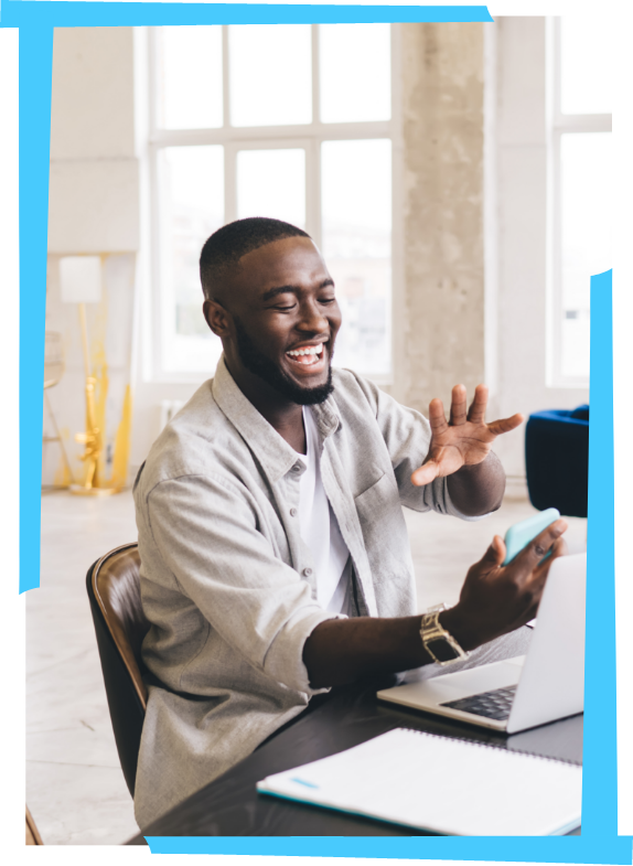 PayrollSolutions1 A happy man sitting at his desk saying hello to someone on the phone